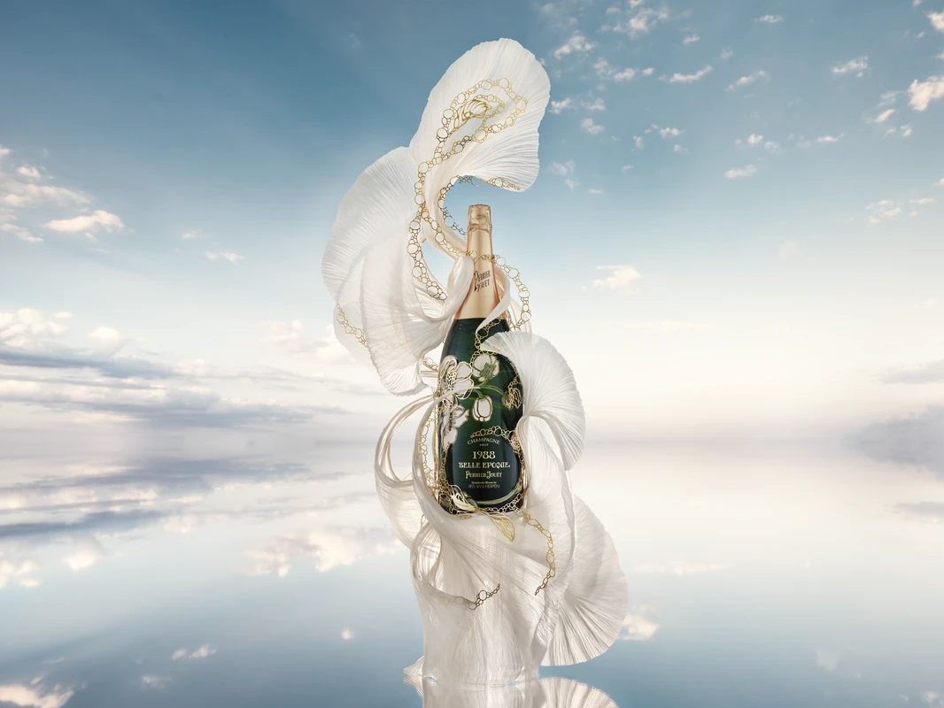 Symphonic Bloom by Iris van Herpen: Perrier-Jouët Belle Epoque 1988 Jeroboam wrapped in sculpted white silk and golden lacework against a reflected sky